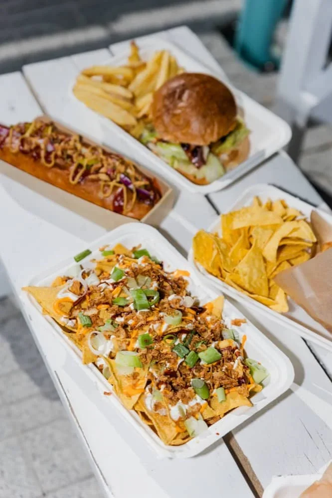 Nachos, hot dogy a burger na stole bistra Lesák